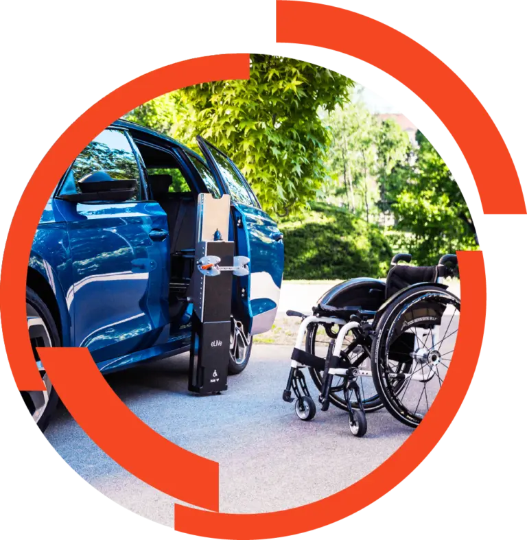 Rollstuhllift neben offenem Autotür eines blauen Wagens, zusammen mit leerem Rollstuhl im Parkumfeld.