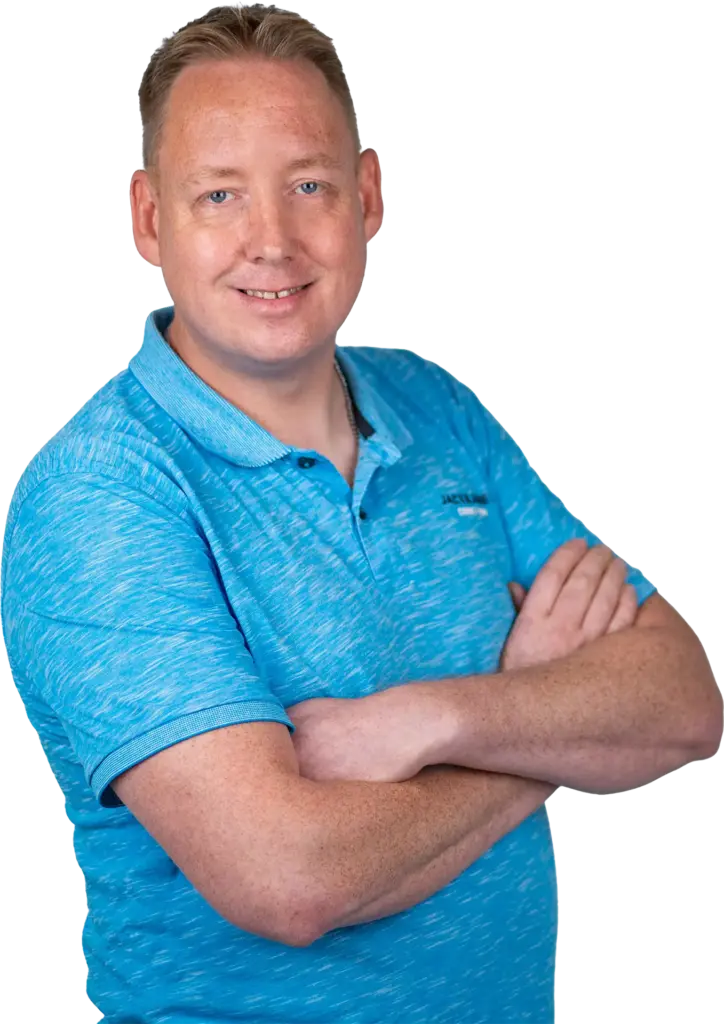 Mann mit blauer Polohemd im Halbporträt, lächelnd und die Arme vor der Brust verschränkt.